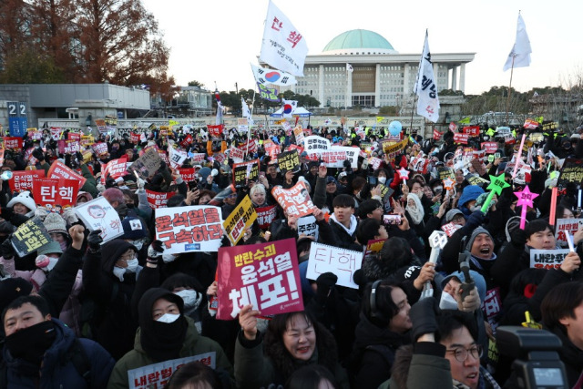 ▲윤석열 대통령 탄핵소추안이 통과된 14일 서울 여의도 국회 앞에서 '윤석열 즉각 퇴진·사회대개혁 비상행동' 주최로 열린 촛불집회에 참가한 시민들이 환호하고 있다. ⓒ연합뉴스