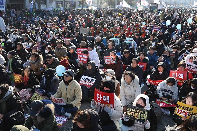 14일 서울 영등포구 여의도 국회 앞에서 열린 윤석열 대통령 탄핵 촉구 집회에서 참석자들이 손팻말을 들고 모여 있다. ⓒ 연합뉴스