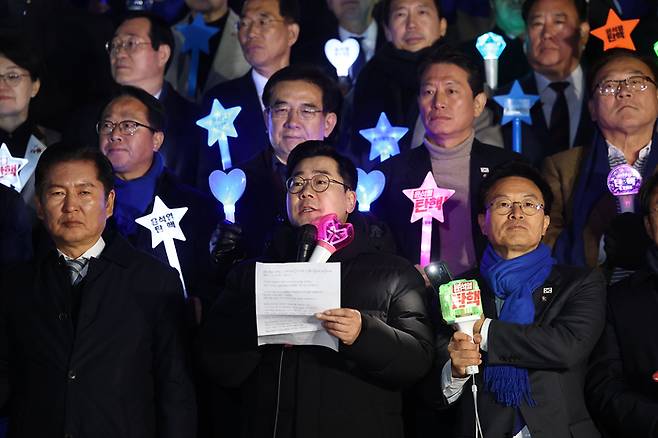 더불어민주당 박찬대 원내대표가 윤석열 대통령에 대한 2차 탄핵소추안 표결을 하루 앞둔 13일 오후 국회 본관 앞에서 응원봉을 들고 결의문을 낭독하고 있다. 사진 | 연합뉴스