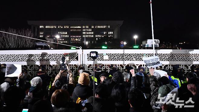 윤석열 대통령이 긴급 담화를 통해 비상계엄을 선포한 가운데 4일 새벽 서울 여의도 국회의사당 정문 앞에서 군·경찰과 대치하던 시민들이 비상계엄 해제 요구 결의안이 가결되자 환호하고 있다. 류영주 기자