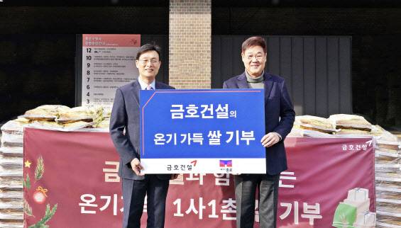 조완석(왼쪽) 금호건설 대표이사가 지난 13일 서울 종로구청을 찾아 정문헌 구청장에게 쌀을 기부한 뒤 기념촬영을 하고 있다.(사진=금호건설)