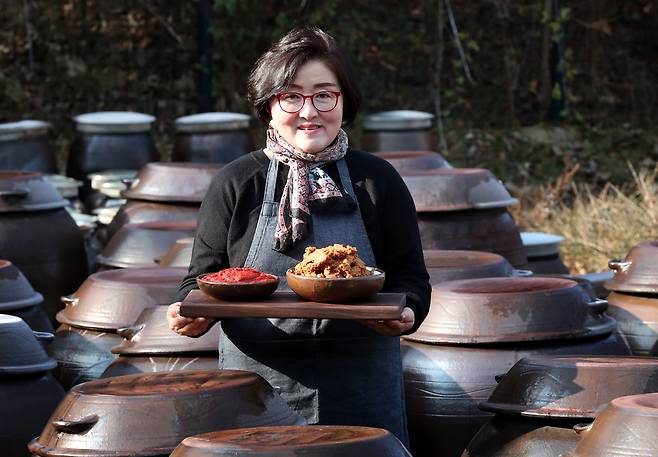 14일 대전 중구 산성동 보문산 자락에 자리한 장독대의 행렬 속에 금중탑골농원 고비송 대표 전통 방식으로 만든 된장과 고추장을 들어 보이고 있다. /신현종 기자