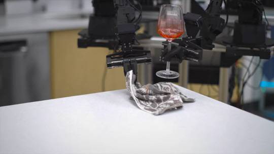 미 스탠포드대와 구글 딥마인드의 알로하 프로젝트 영상 캡쳐. 로봇팔이 와인잔을 들고, 다른 팔로 바닥을 닦고 있다. 스탠포드대 유튜브 영상 캡쳐