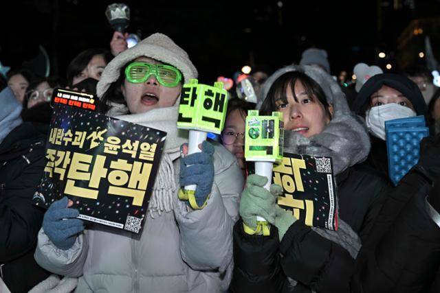 14일 응원봉을 든 촛불 집회 참가자들이 서울 영등포구 여의도 국회의사당 앞에서 윤석열 대통령에 대한 탄핵소추안 가결 여부를 기다리고 있다. 정다빈 기자