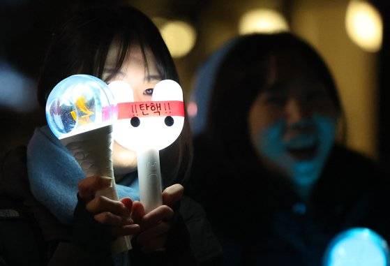 윤석열 대통령 탄핵소추안이 가결된 지난 14일 서울 여의도 국회 앞 집회에서 시민들이 탄핵봉을 들고 있다. [연합뉴스]