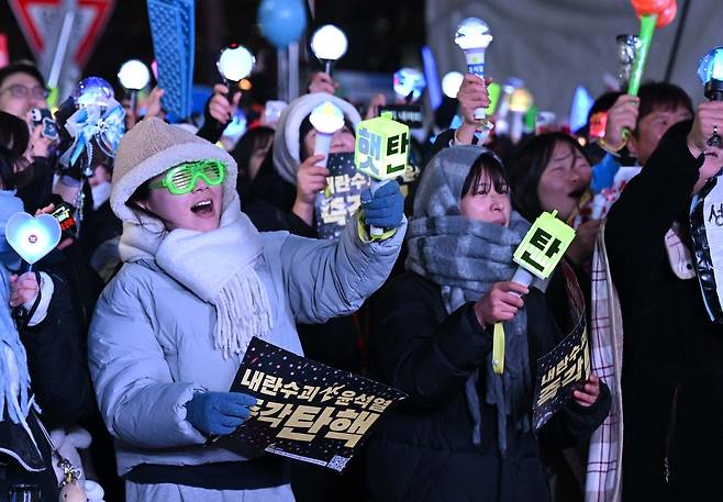 윤석열 대통령 탄핵소추안이 가결된 14일 오후 서울 여의도 국회 앞에서 열린 집회에 참석한 시민들이 환호하고 있다. 임세준 기자