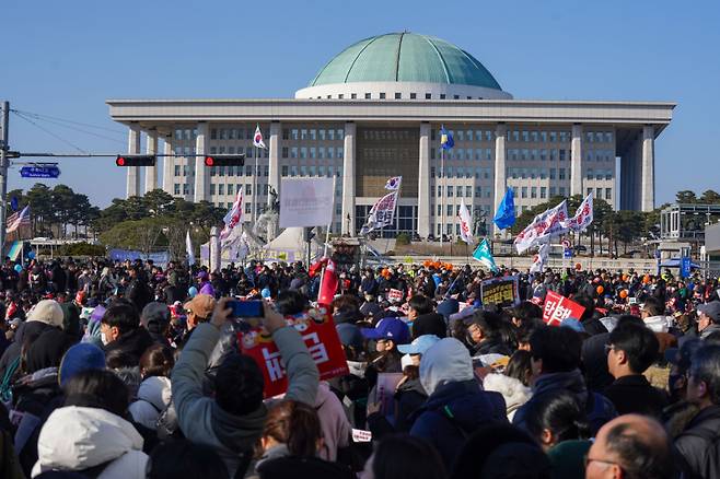 윤석열 대통령 탄핵소추안 표결이 이뤄진 14일 오후 서울 영등포구 여의도 국회 앞에서 시민들이 손팻말을 들고 시위하고 있다. 사진=유희태 기자