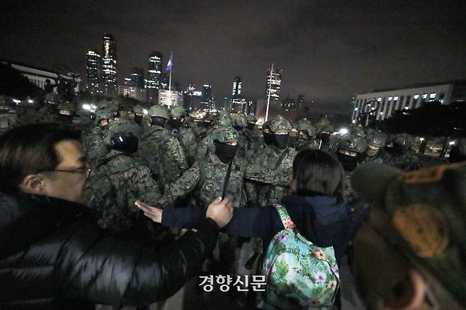 윤석열 대통령이 12·3 비상계엄 선포한 직후인 지난 4일 계엄군이 서울 여의도 국회 본관으로 진입을 시도하자 시민들이 손을 이어잡아 저지하고 있다. 한수빈 기자