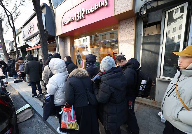 윤석열 대통령에 대한 탄핵소추안이 국회에서 가결된 14일 서울 여의도 한 카페에서 조국 조국혁신당 전 대표가 선결제한 커피를 받기 위해 사람들이 줄을 서 있다. /연합뉴스