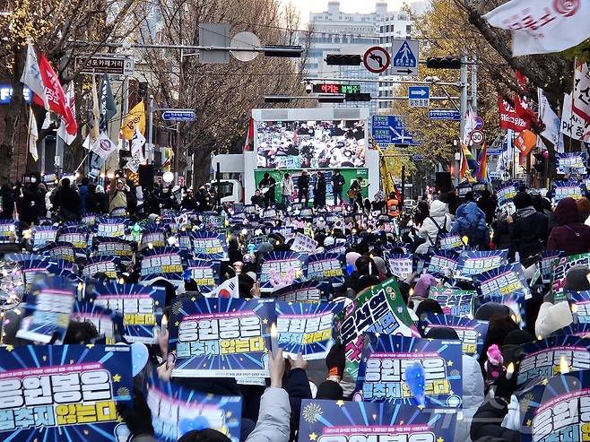 21일 부산 부산진구 서면 놀이마루 앞에서 열린 윤석열 구속·파면 부산시민대회에서 집회 참가자들이 피켓과 응원봉을 흔들고 있다.2024.12.21/ 뉴스1 ⓒ News1 조아서 기자