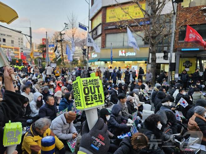 21일 부산 부산진구 서면 놀이마루 앞에서 열린 윤석열 구속·파면 부산시민대회에서 한 참가자가 '윤석열 OUT 탄핵'이라고 적힌 아이돌 응원봉을 흔들고 있다.2024.12.21/ 뉴스1 ⓒ News1 조아서 기자