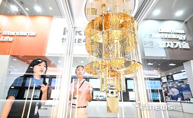 퀀텀코리아에서 참관객이 한국표준과학연구원의 초전도 기반 50큐비트 양자컴퓨터 모형을 살펴보고 있다.