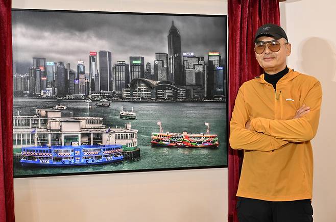 주윤발이 홍콩 하버시티에서 열린 사진전 '홍콩 아침' 작품 앞에서 기념 촬영하고 있다. /하버시티 X(옛 트위터)