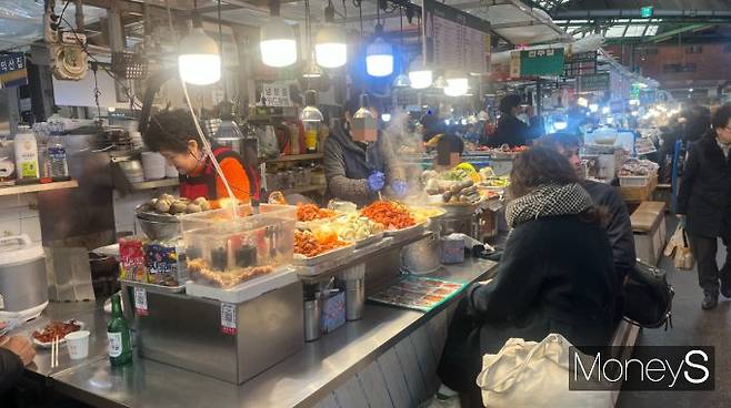 20일 오후 광장시장의 한 노점에서 외국인 관광객이 음식을 기다리며 앉아 있다. /사진=곽선우 기자