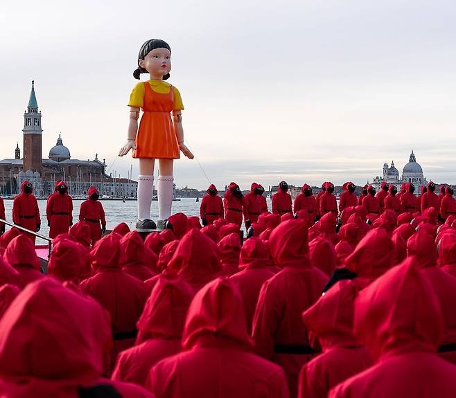 이탈리아 베네치아 부둣가에 지난 20일(현지 시각) ‘오징어 게임’ 마스코트인 ‘영희’ 인형을 태운 배가 떠 있고, 분홍색 점프 슈트를 입은 진행 요원들이 주변을 둘러싸고 있다. 시즌2 공개를 앞두고 서울·파리·시드니·방콕 등 주요 도시의 랜드마크에 영희 인형이 등장했다. /넷플릭스