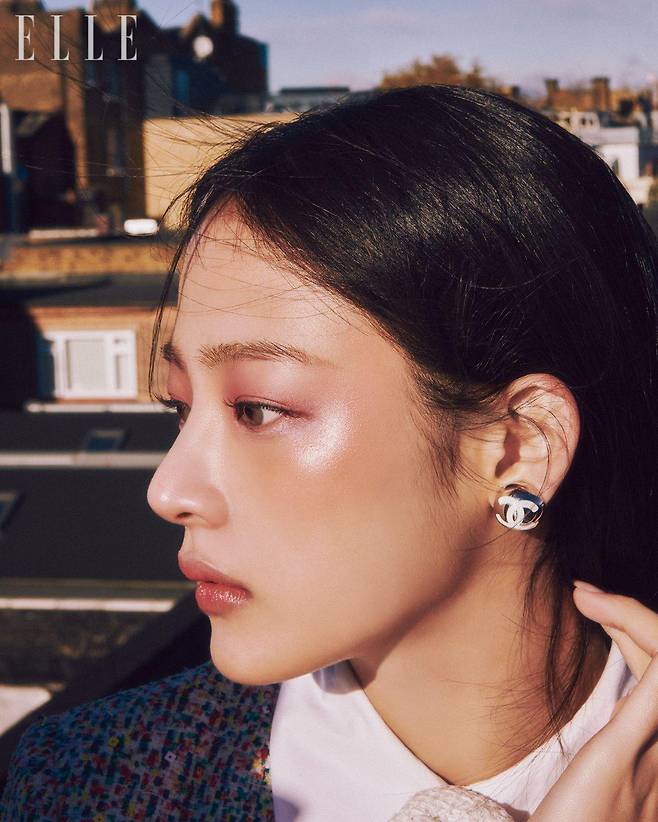 스틸로 쑤르씰 오뜨 프레시지옹, 154 블롱 땅드르로 한 올 한 올 또렷한 눈썹을 연출하고 레 베쥬 아이섀도우 팔레트, 쿨에 들어 있는 섬세한 핑크 시머와 보랏빛 로즈우드로 눈가를 물들여 신비로운 모브빛을 발하도록 표현한다. N°1 DE CHANEL 레드 까멜리아 립 앤 치크 밤, 2 헬시 핑크와 아이섀도의 시머리한 질감이 한데 어우러지도록 펴 발라 혈색과 광채를 더한 뒤 루쥬 코코 플래쉬, 90 쥬르를 입술에 발라 마무리. 사용 제품은 모두 Chanel. 트위드 재킷과 화이트 까멜리아 코르사주, 이어링은 모두 Chanel.