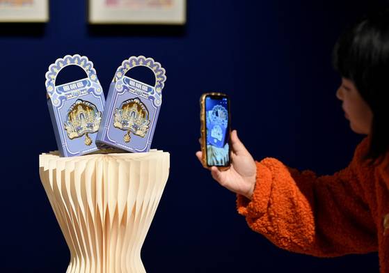 '2024 원명원(圓明園) 인상∙황실 '여행' 문화크리에이티브디자인 전시회'를 방문한 관람객이 인공지능(AI) 크리에이티브 마그넷을 휴대전화에 담고 있다. 신화통신