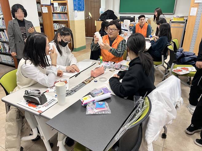 한화에어로스페이스 임직원이 19일 전남 여수 개도중에서 진행된 ‘우주항공 과학교실’에서 학생들과 함께 모형을 만들고 있는 모습   [한화에어로스페이스]