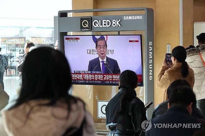 서울역에서 한덕수 권한대행 담화 시청하는 시민들 (서울=연합뉴스) 이진욱 기자 = 26일 오후 서울역에서 시민들이 한덕수 대통령 권한대행 국무총리 대국민 담화를 시청하고 있다. 2024.12.26 cityboy@yna.co.kr