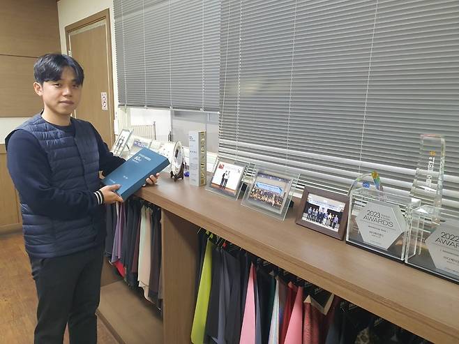 최원빈 차장이 직물산업 발전사 60년사 책을 들어보이고 있다. 안산=윤현주 기자
