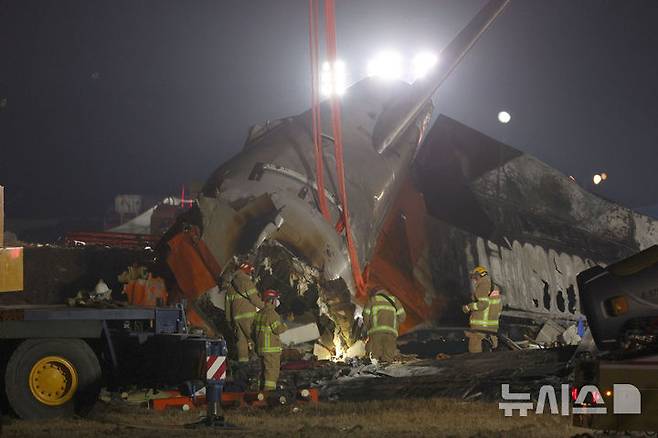 [무안=뉴시스] 김선웅 기자 = 29일 전남 무안국제공항에서 발생한 태국발 제주항공 여객기 충돌 폭발 사고 현장에서 소방대원들이 야간 수색 작업을 진행하고 있다. 2024.12.29. mangusta@newsis.com