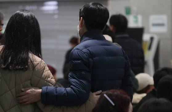 Bereaved families of those killed in the fatal plane crash at Muan International Airport listen to fire authorities' announcement of identified victims at the airport on Dec. 29. [YONHAP]