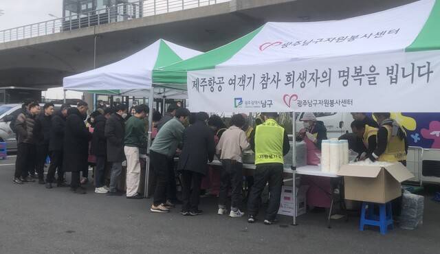 광주남구자원봉사센터 회원들이 30일 무안국제공항 주차장 한쪽에서 제주항공 여객기 참사 유족과 관계자들에게 무료 도시락을 나눠주고 있다.