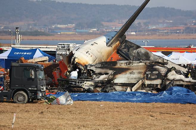 29일 전남 무안군 무안국제공항에서 발생한 제주항공 여객기 충돌 폭발 사고 현장에서 소방구급대원이 사고 여객기 내부를 수색하고 있다. [연합]