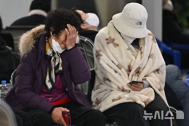 [무안=뉴시스] 이영주 기자 = 제주항공 소속 여객기 착륙 도중 충돌 사고 이튿날인 30일 오전 전남 무안군 무안국제공항 2층 대합실에서 한 유족이 눈물을 닦고 있다. 2024.12.30. leeyj2578@newsis.com