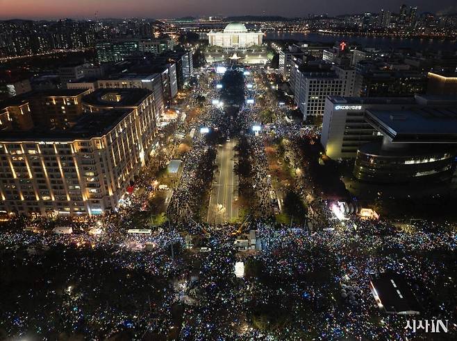 12월14일 저녁, 윤석열 대통령 탄핵소추안이 국회에서 가결된 후 국회 앞에 모인 시민들이 촛불과 응원봉을 흔들며 환호하고 있다. ⓒ시사IN 이명익