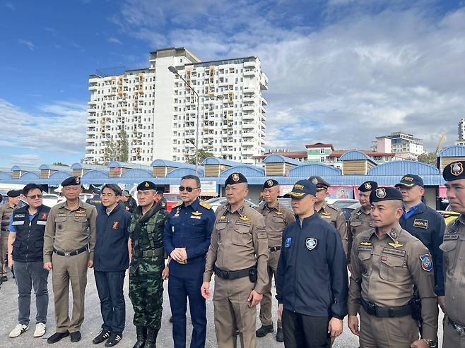 태국 경찰 당국이 지난 28일(현지시간) 캄보디아와 접경 지역인 태국 동부 사깨우주에서 보이스피싱 등 국제적 사기를 벌이는 것으로 의심되는 캄보디아 소재 대규모 사기 작업장 관련 단속을 벌이는 모습. 사기 작업장이 있는 것으로 의심되는 캄보디아 서부 포이펫 지역의 25층 건물이 뒤쪽으로 보인다. 2024.12.30
[카오솟 홈페이지 캡처. 재판매 및 DB 금지]