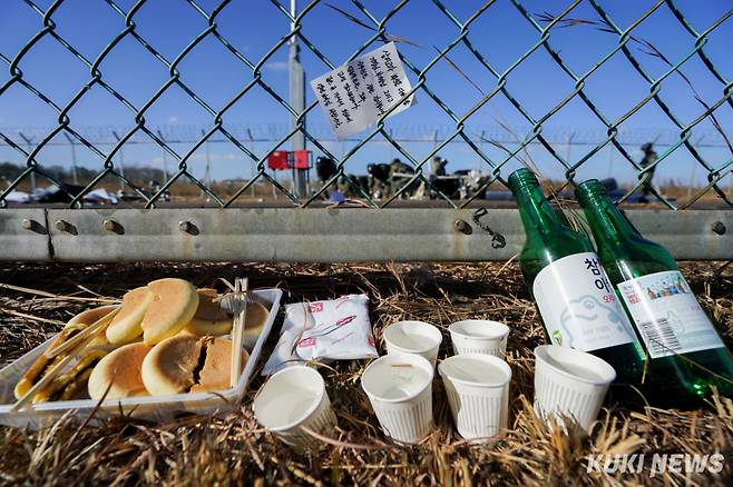 제주항공 여객기 참사 사흘째인 31일 전남 무안국제공항 사고 현장에 추모글과 빵, 술 등이 놓여 있다.
