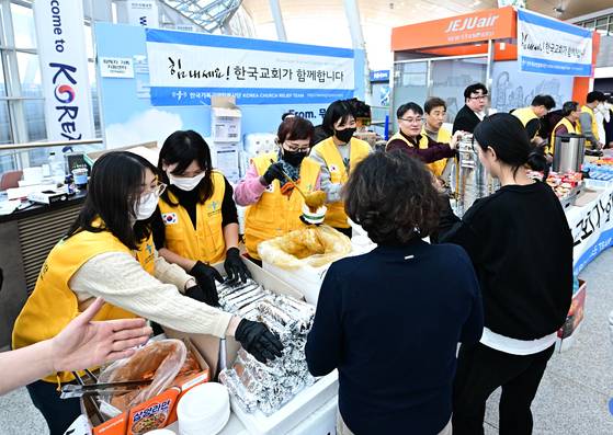 지난해 12월 31일 무안국제공항에서 자원봉사 단체들이 먹거리를 나눔하고 있다. 장진영 기자