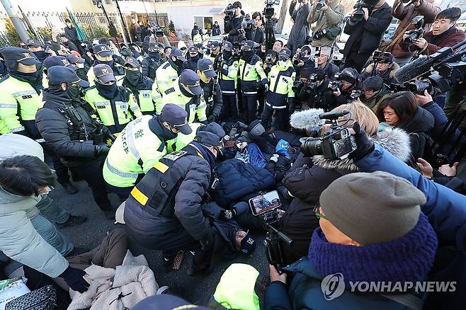 대통령 관저 앞 지지자 해산시키는 경찰 (서울=연합뉴스) 임화영 기자 = 윤석열 대통령에 대한 체포영장 발부 사흘째인 2일 서울 용산구 한남동 대통령 관저 정문 앞 도로에 누워있는 지지자들을 경찰들이 해산시키려 하고 있다. 2025.1.2 hwayoung7@yna.co.kr