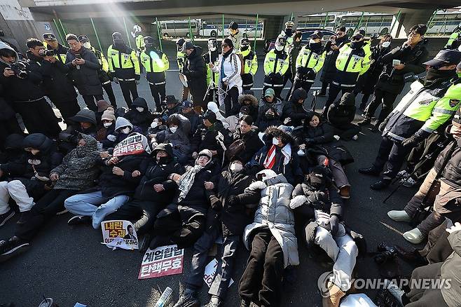 도로에 누워있는 윤석열 대통령 지지자 (서울=연합뉴스) 김성민 기자 = 고위공직자범죄수사처가 내란 수괴(우두머리)·직권남용 혐의를 받는 윤석열 대통령의 체포영장을 유효기간인 6일 이전에 집행하겠다고 밝힌 가운데 2일 서울 용산구 한남동 대통령 관저 정문 앞 도로에 지지자들이 누워있다. 2025.1.2 ksm7976@yna.co.kr