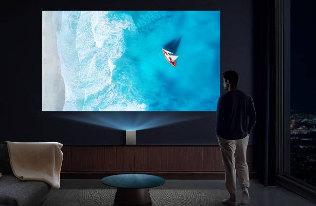 LG전자 모델이 CES 2025에서 공개되는 신개념 라이프스타일 프로젝터 ‘초소형 LG 시네빔 쇼츠’를 통해 가까운 거리에서 투사된 대화면으로 콘텐츠를 감상하고 있다.  LG전자 제공