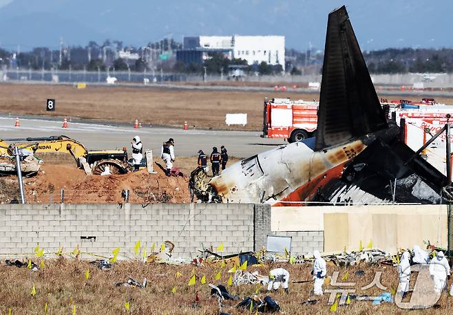 제주항공 여객기 참사 엿새째인 3일 오후 전남 무안국제공항 참사 현장에서 국과수 관계자들이 로컬라이저(방위각시설) 둔덕에 파묻힌 엔진을 살펴보고 있다. 2025.1.3/뉴스1 ⓒ News1 오대일 기자