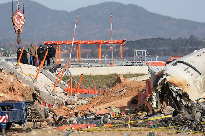 2024년 12월31일 전남 무안국제공항 ‘제주항공 참사’ 현장에서 미국 연방교통안전위원회(NTSB) 관계자들을 비롯한 한미합동조사단이 사고 여객기 기체와 방위각 제공시설이 설치됐던 콘크리트 구조물 등을 살펴보고 있다. 한겨레 김영원 기자