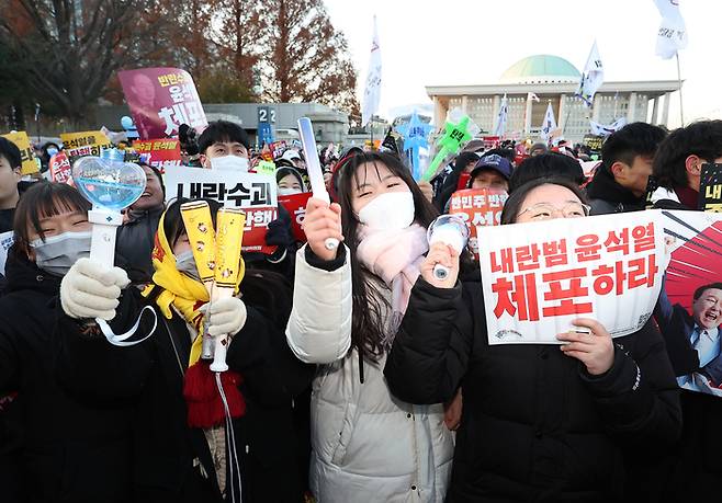 2024년 12월 14일 서울 여의도 국회 앞에서 열린 윤석열 대통령 탄핵 촉구 집회에서 시민들이 손팻말과 응원봉을 들고 있다. 연합뉴스