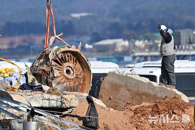 [무안=뉴시스] 이영주 기자 = 제주항공 참사 엿새째인 3일 오전 전남 무안군 무안국제공항 활주로 로컬라이저 잔해에서 국토교통부 항공철도사고조사위원회 조사단이 사고 여객기 엔진부를 크레인을 이용해 들어올리고 있다. 2025.01.03. leeyj2578@newsis.com