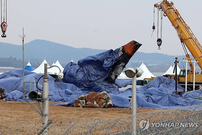 방수포 덮인 사고 여객기 (무안=연합뉴스) 조남수 기자 = 5일 오후 전남 무안국제공항 참사 현장 사고 여객기 꼬리 날개에 방수포가 덮여 있다. 2025.1.5 iso64@yna.co.kr