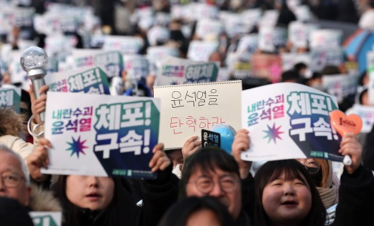 윤석열 대통령의 체포영장 유효기간 마지막 날인 6일 서울 용산구 한남동 대통령 관저 인근에서 열린 집회에서 윤 대통령 체포·구속을 촉구하는 피켓을 들고 있다. (사진 / 뉴스1)