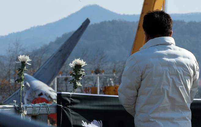 지난 1월 2일 오후 전남 무안국제공항 제주항공 참사 현장에서 한 시민이 사고 여객기를 바라보고 있다. 연합뉴스