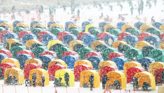 5일 오후 강원 평창군 진부면 오대천 일원에서 제16회 평창송어축제를 찾은 방문객들이 눈발이 날리는 가운데 얼음송어낚시를 즐기고 있다. 뉴스1