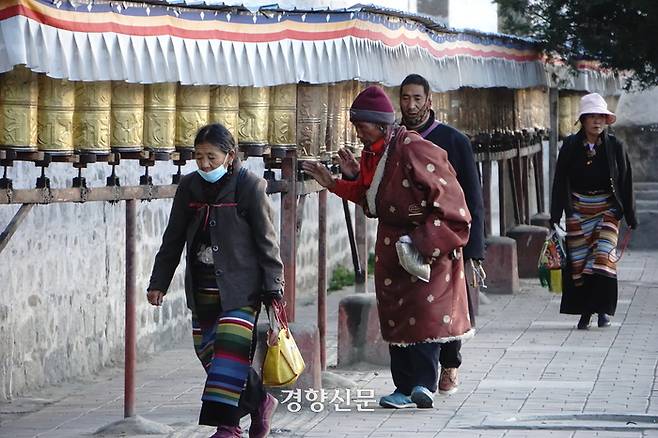 르카쩌 타시룸포 사원 앞에서 티베트인들이 마니차(경전이 써 있는 통)를 돌리고 있다. 2021년 10월 촬영. / 경향신문 자료사진