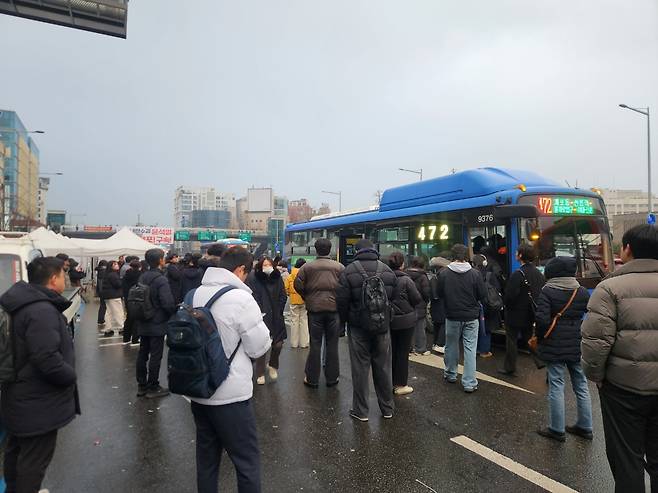 지난 6일 서울 용산구 한남동 한남대로 부근의 한 버스 정류장. 집회로 인해 일부 도로가 마비되자 도로까지 걸어나가 버스에 탑승하는 모습. 이영기 기자.