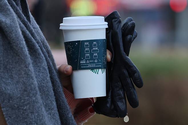 서울 청계광장에서 한 시민이 커피를 손에 든 채 출근하고 있다. /뉴스1