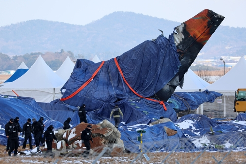 전남 무안군 무안국제공항에서 항공철도사고조사위원회 관계자와 경찰특공대원이 사고 현장을 살피고 있는 모습. [사진 출처 = 연합뉴스]