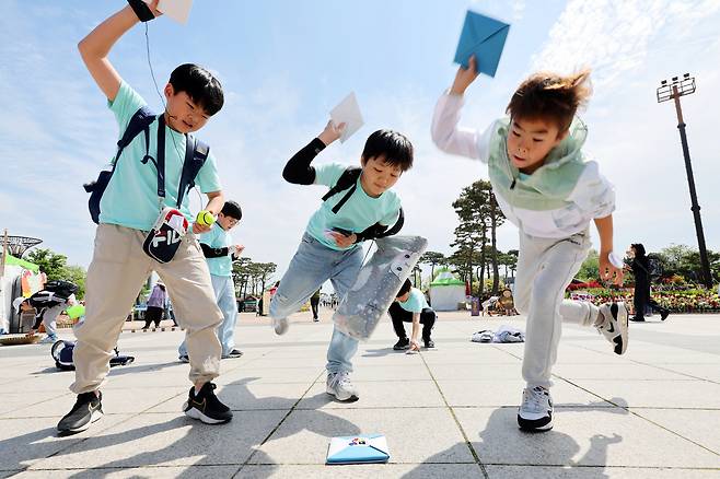 Children play ddakji chigi (throwing folded paper) in Hampyeong County, South Jeolla, on April 26. [YONHAP]