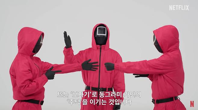 The henchmen, or Pink Guards, from Netflix's "Squid Game" demonstrate how to play rock, paper, scissors, minus one in a YouTube video. [SCREEN CAPTURE]